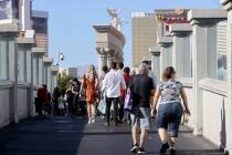 La gente camina por el puente peatonal entre el Bellagio y el Caesars Palace en el Strip de Las ...
