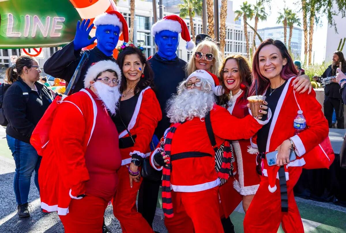 Los participantes se reúnen con el Blue Man Group en la fila de salida durante la Great Santa ...