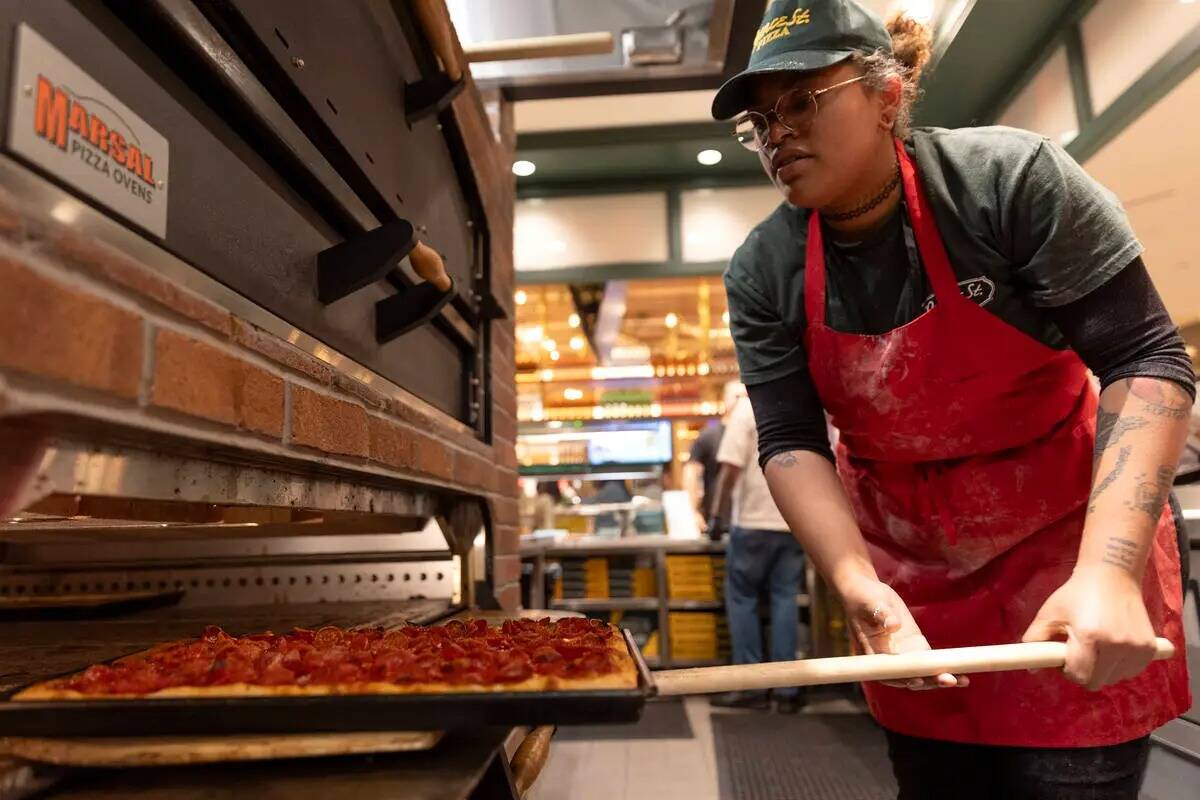 La pizzera Aiyiko Batiste saca una tarta de pepperoni del horno de Prince Street Pizza durante ...