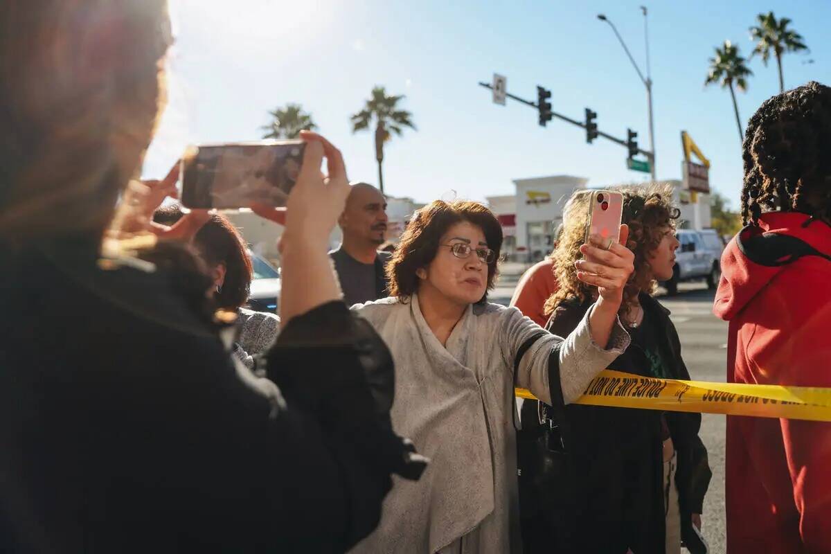 La gente graba y escucha a la policía en la escena de un tiroteo en el campus de la UNLV el mi ...