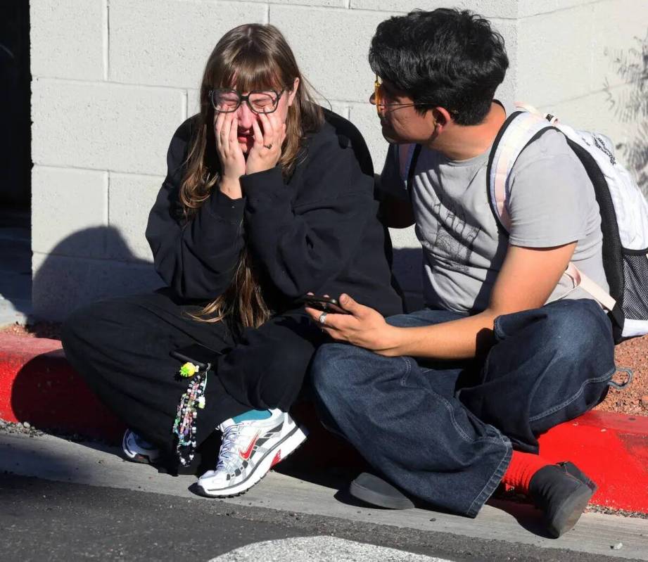 Amanda Pérez es consolada por su compañero Alejandro Barron cerca de Maryland Parkway tras un ...