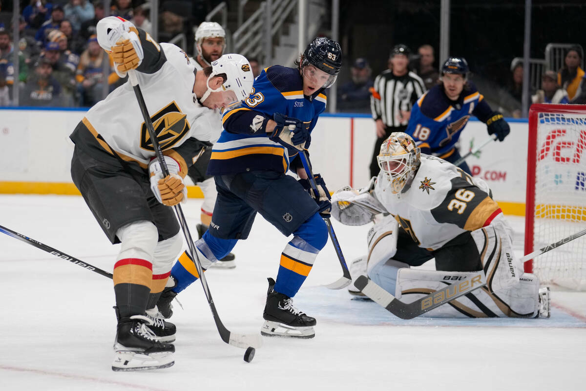 Ben Hutton de Vegas Golden Knights, izquierda, maneja el puck mientras el portero de Golden Kni ...