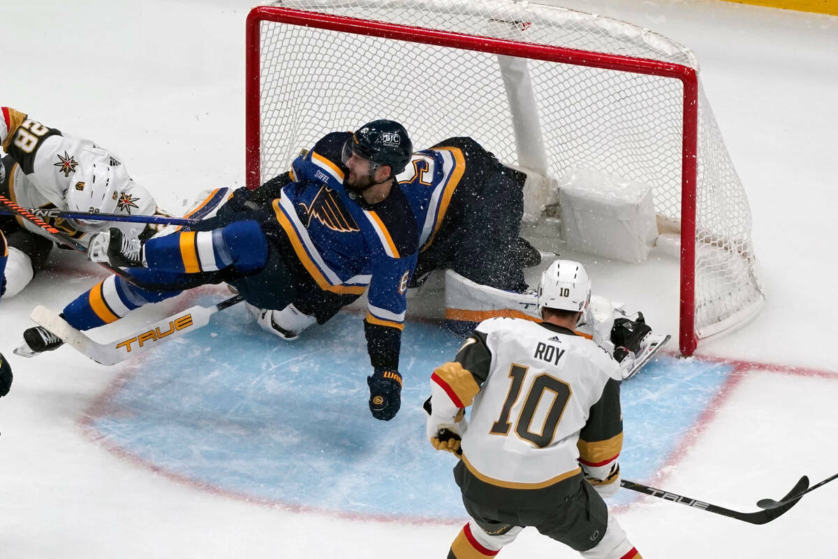 Marco Scandella de St. Louis Blues, izquierda, cae mientras Nicolas Roy (10) de Vegas Golden Kn ...