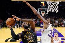 El alero de los Los Angeles Lakers LeBron James, a la izquierda, lanza a canasta mientras el al ...