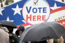 Personas esperan en fila para emitir su voto en el centro de votación Centennial Center, en La ...