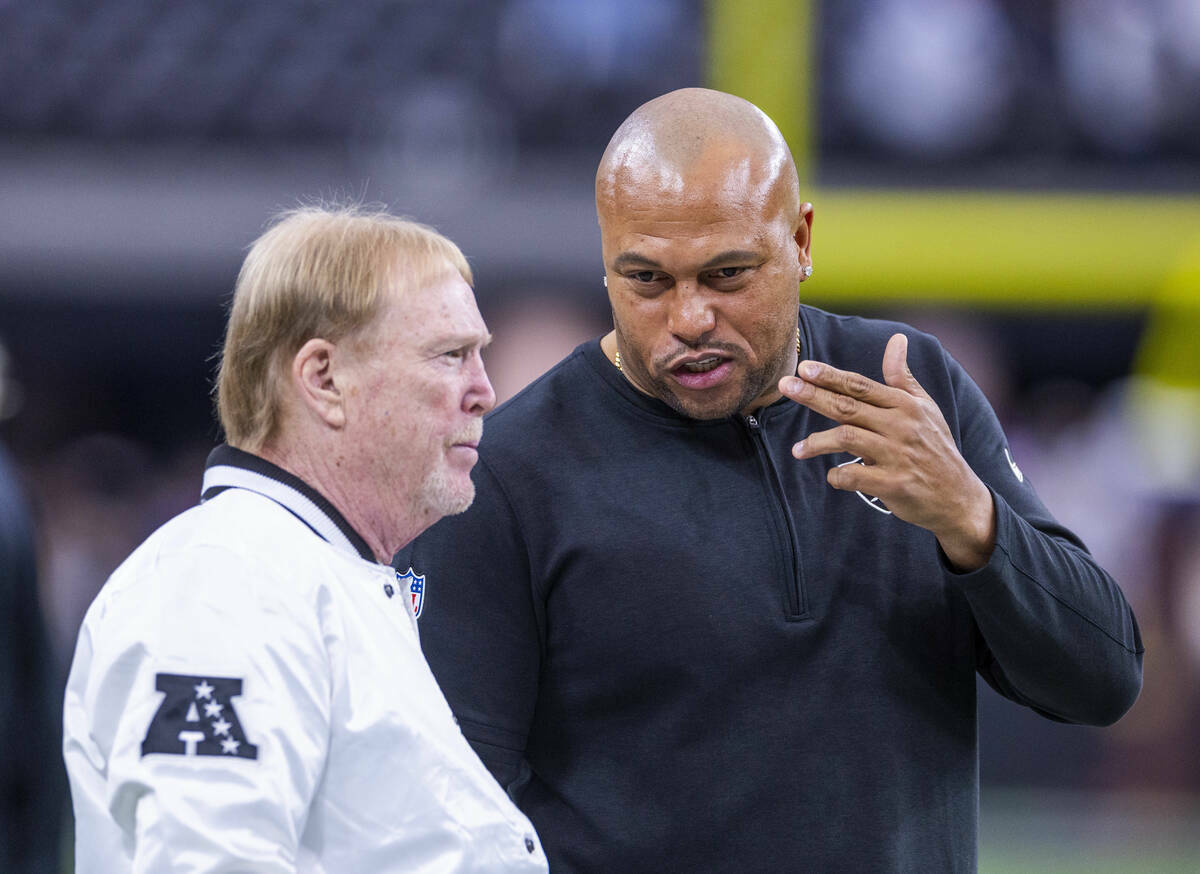 El propietario de los Raiders, Mark Davis, charla con el entrenador en jefe interino Antonio Pi ...