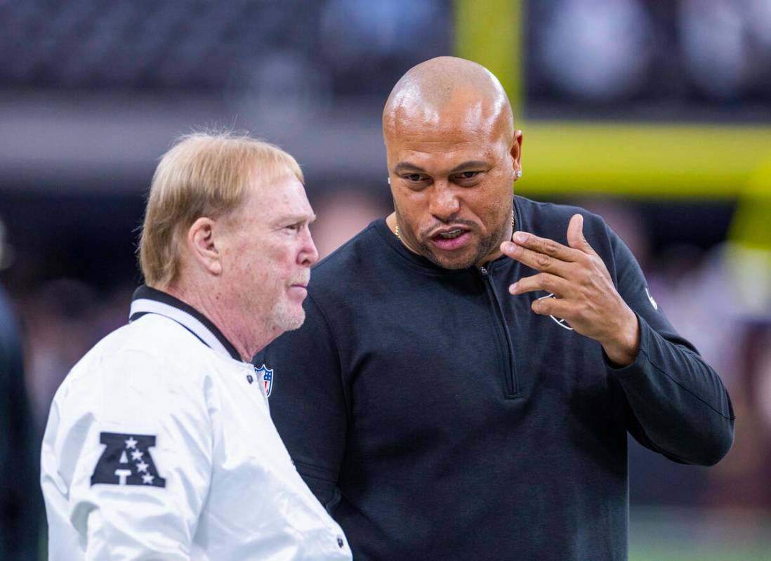 El propietario de los Raiders, Mark Davis, charla con el entrenador en jefe interino Antonio Pi ...