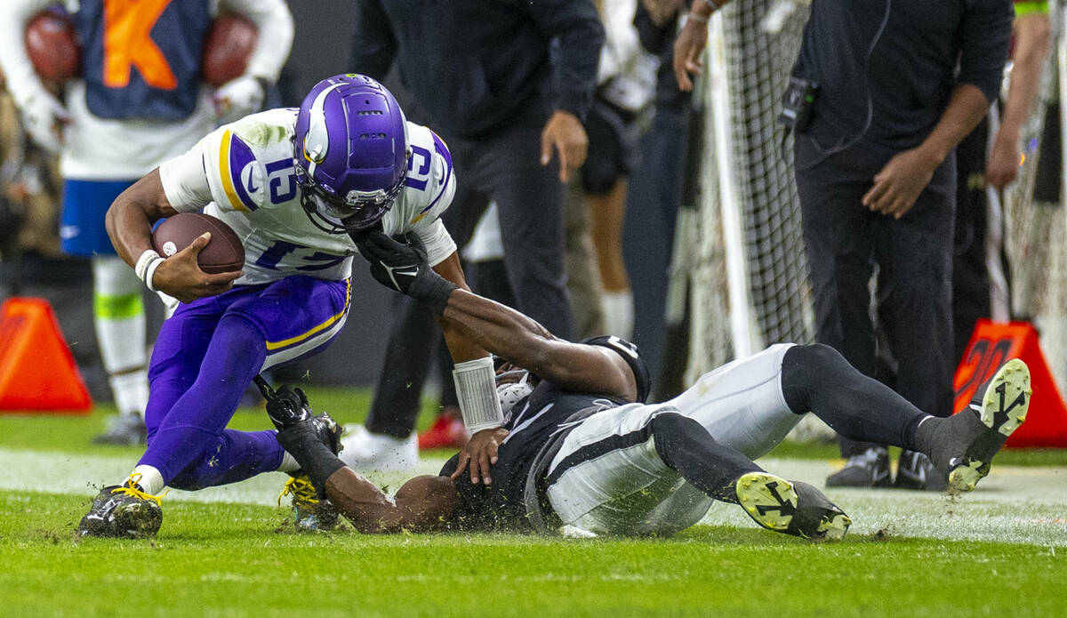 El quarterback de los Minnesota Vikings Joshua Dobbs (15) es derribado tras una carrera por el ...