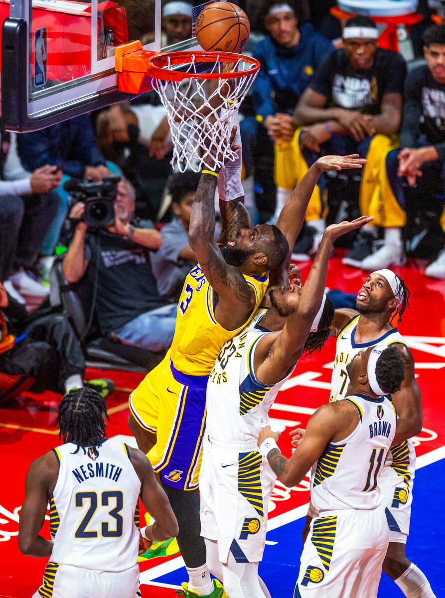 El alero de Los Angeles Lakers LeBron James (23) lanza contra el alero de Indiana Pacers Aaron ...