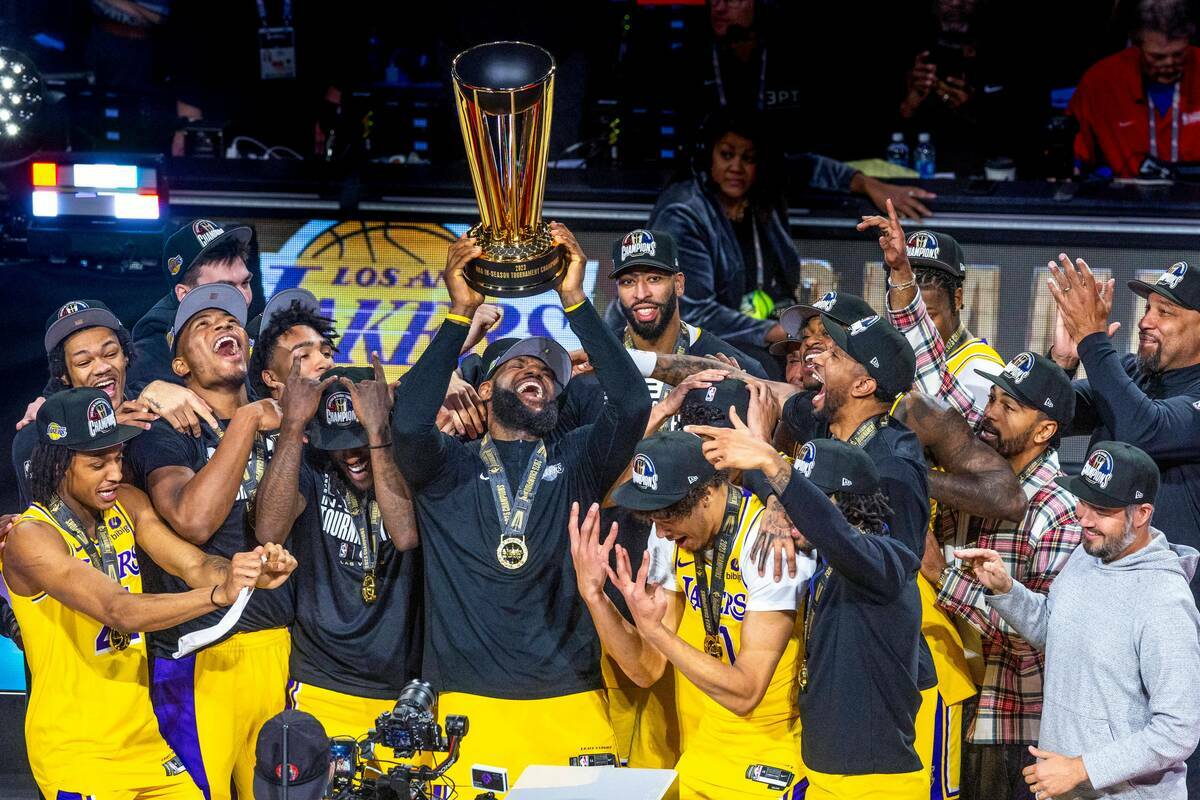 El alero de Los Angeles Lakers LeBron James (23) sostiene el trofeo de ganador por encima de su ...