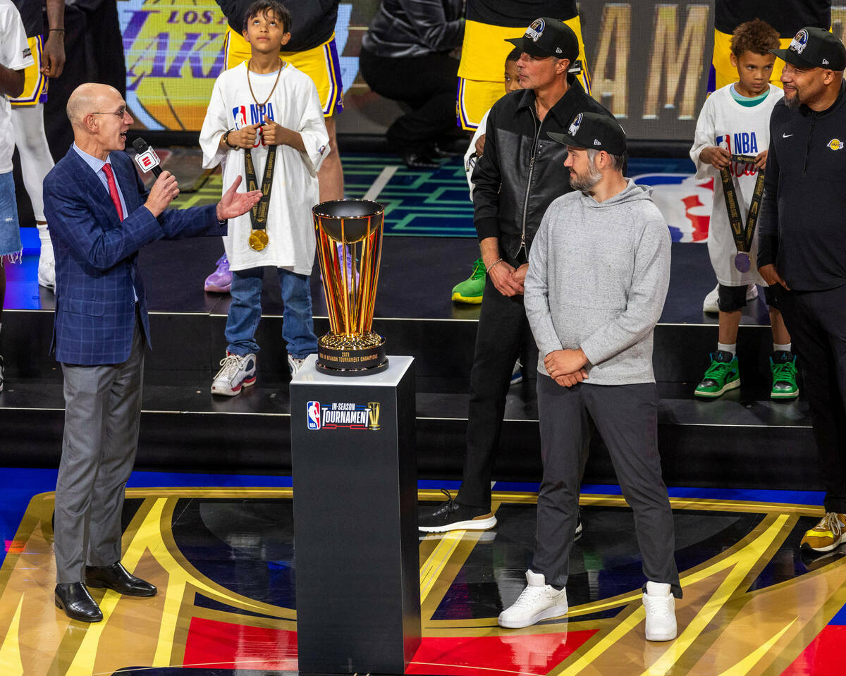 El comisionado de la NBA, Adam Silver, a la izquierda, entrega el trofeo de ganador a Los Angel ...