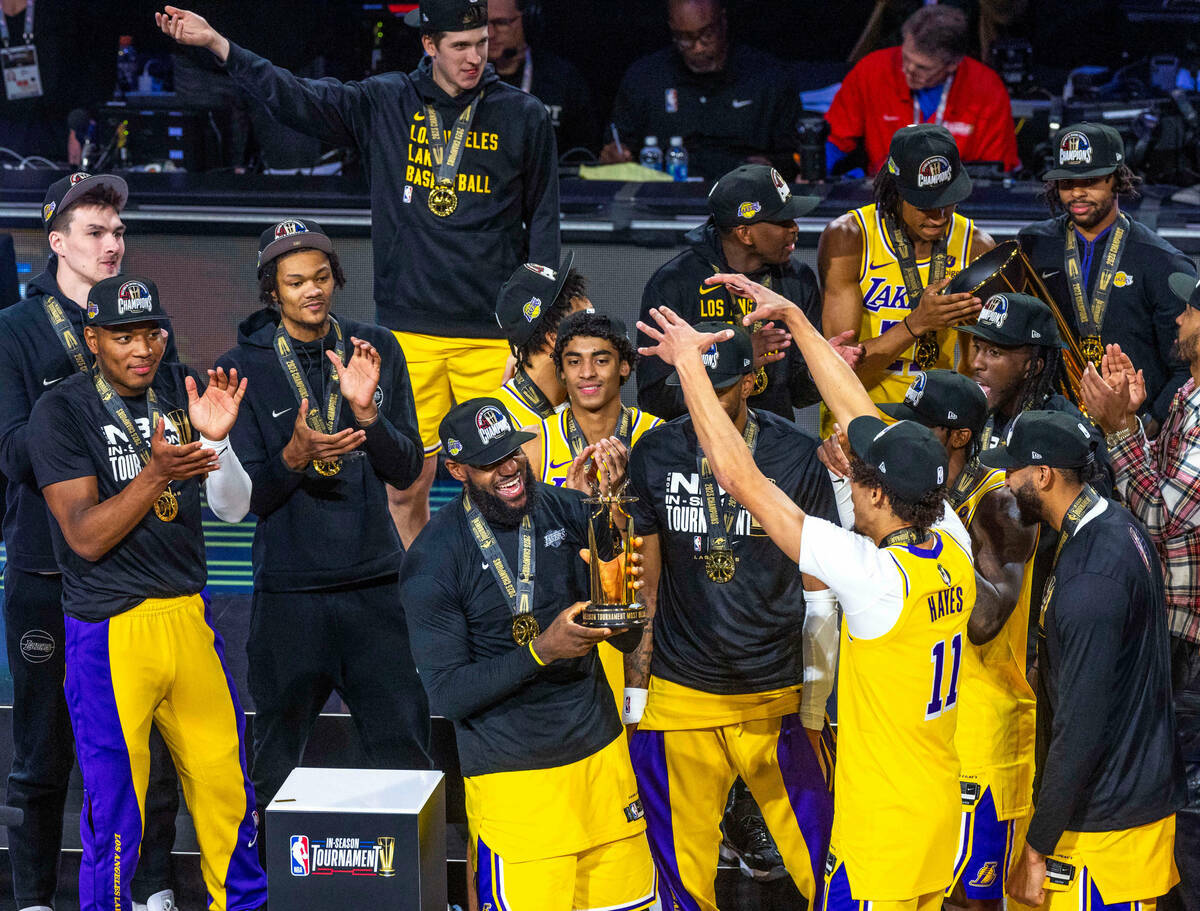 El alero de Los Angeles Lakers LeBron James (23) sostiene su trofeo de MVP ante sus compañeros ...