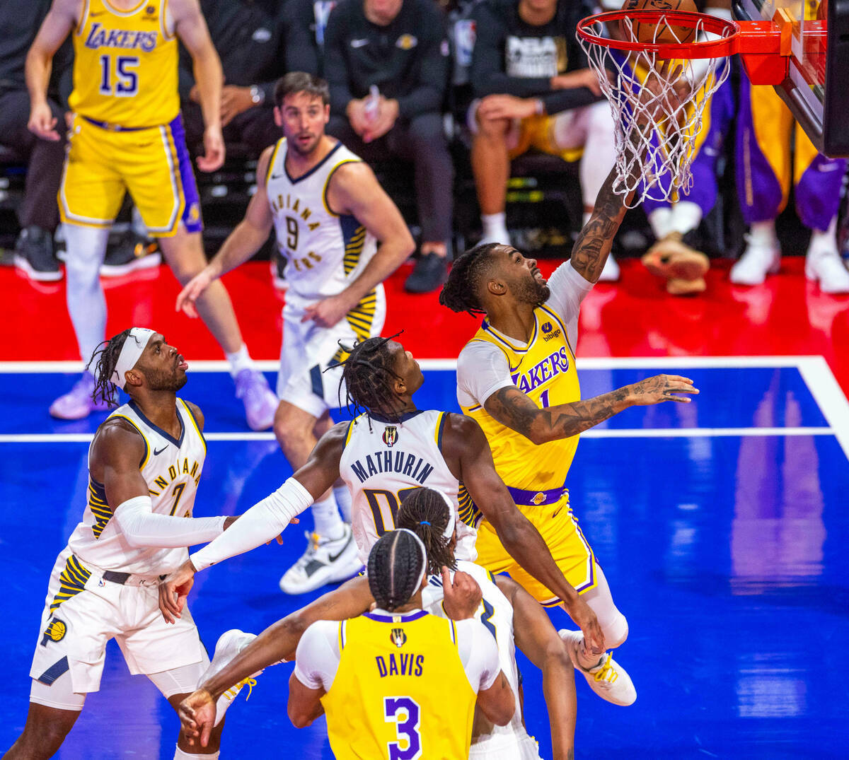 El escolta de Los Angeles Lakers D'Angelo Russell (1) llega a la canasta superando al escolta d ...