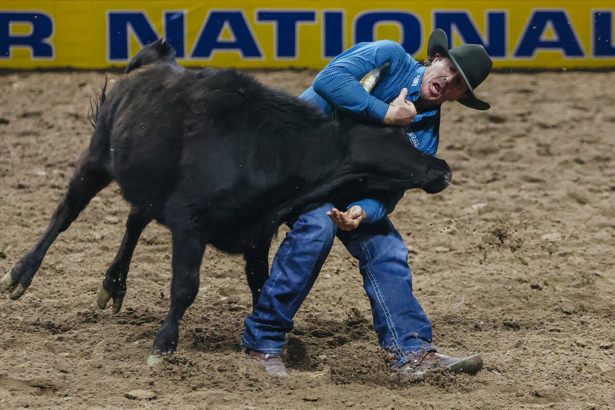 Nick Guy lucha con un novillo durante el tercer día del National Finals Rodeo en el Thomas & M ...