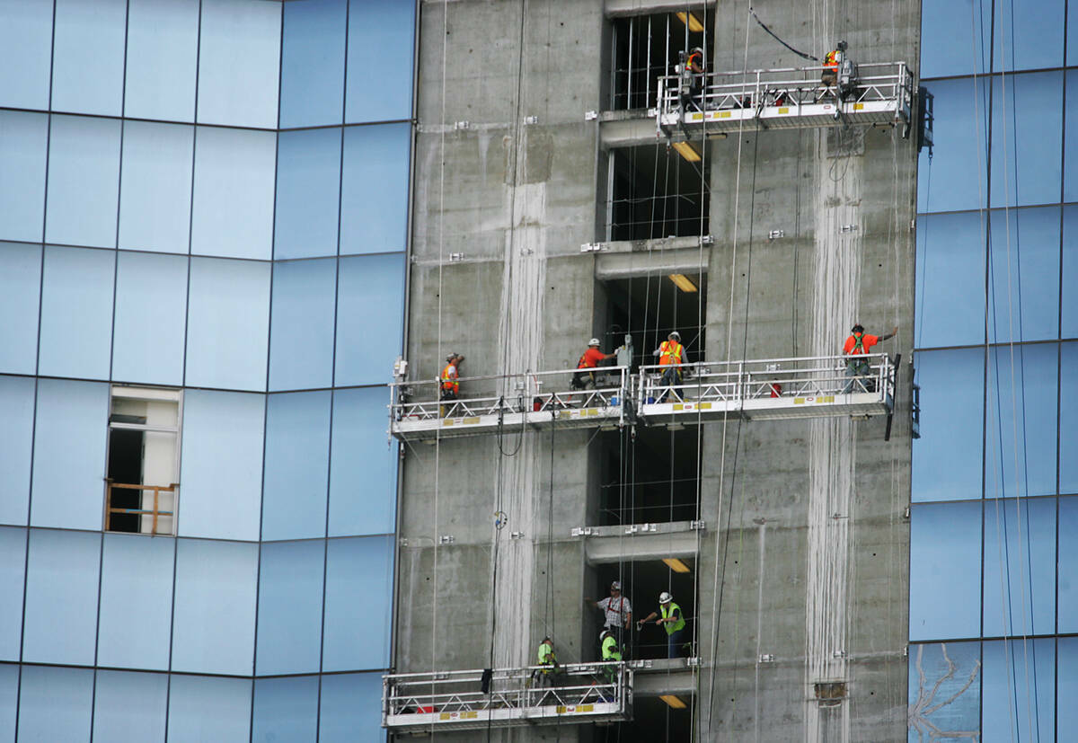 Obreros de la construcción cuelgan sobre el Strip mientras intentan terminar el Fontainebleau, ...