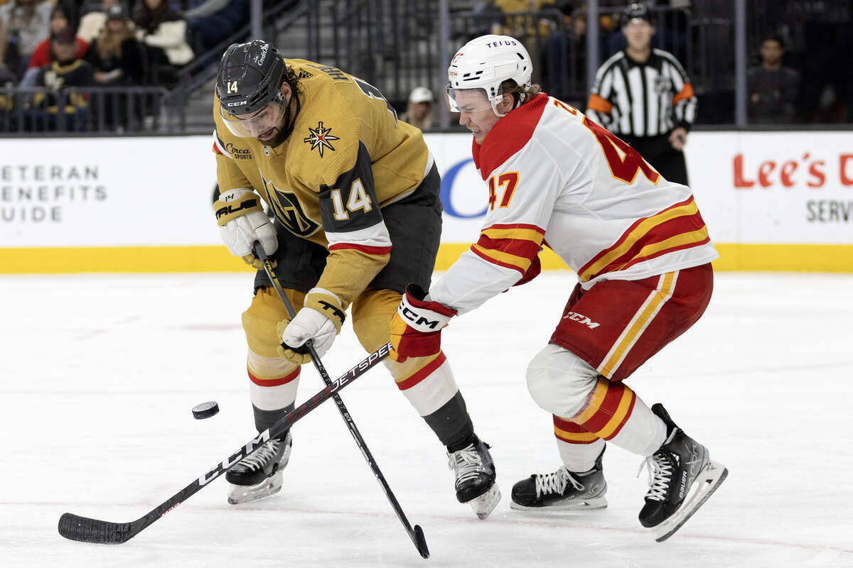 El defensa de los Golden Knights Nicolas Hague (14) y el centro de los Flames Connor Zary (47) ...