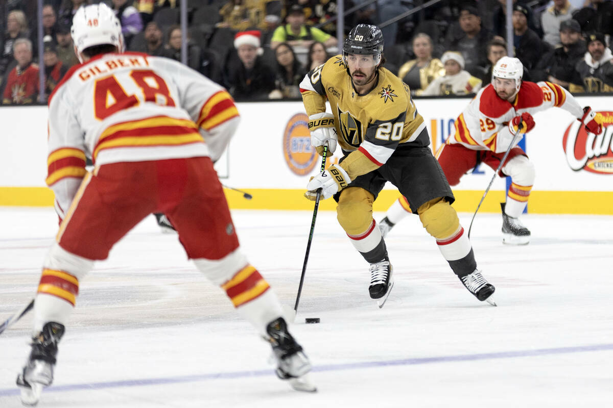 El centro de los Golden Knights Chandler Stephenson (20) patina con el puck contra el defensa d ...