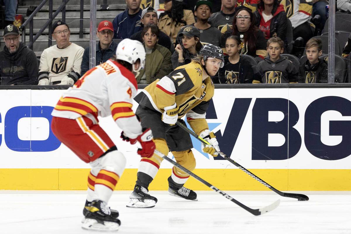 El centro de los Golden Knights William Karlsson (71) patina hacia la red contra el defensa de ...