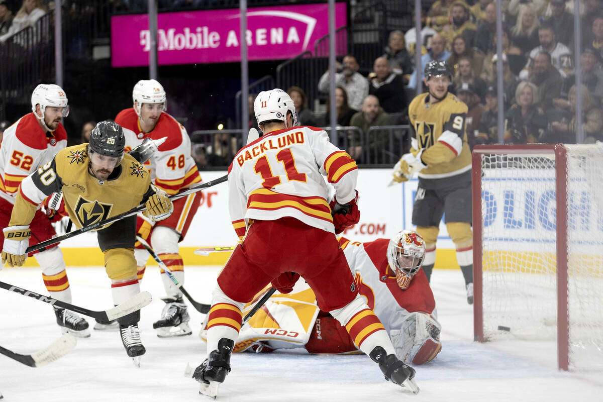 El centro de los Golden Knights Chandler Stephenson (20) marca un gol al portero de los Flames ...