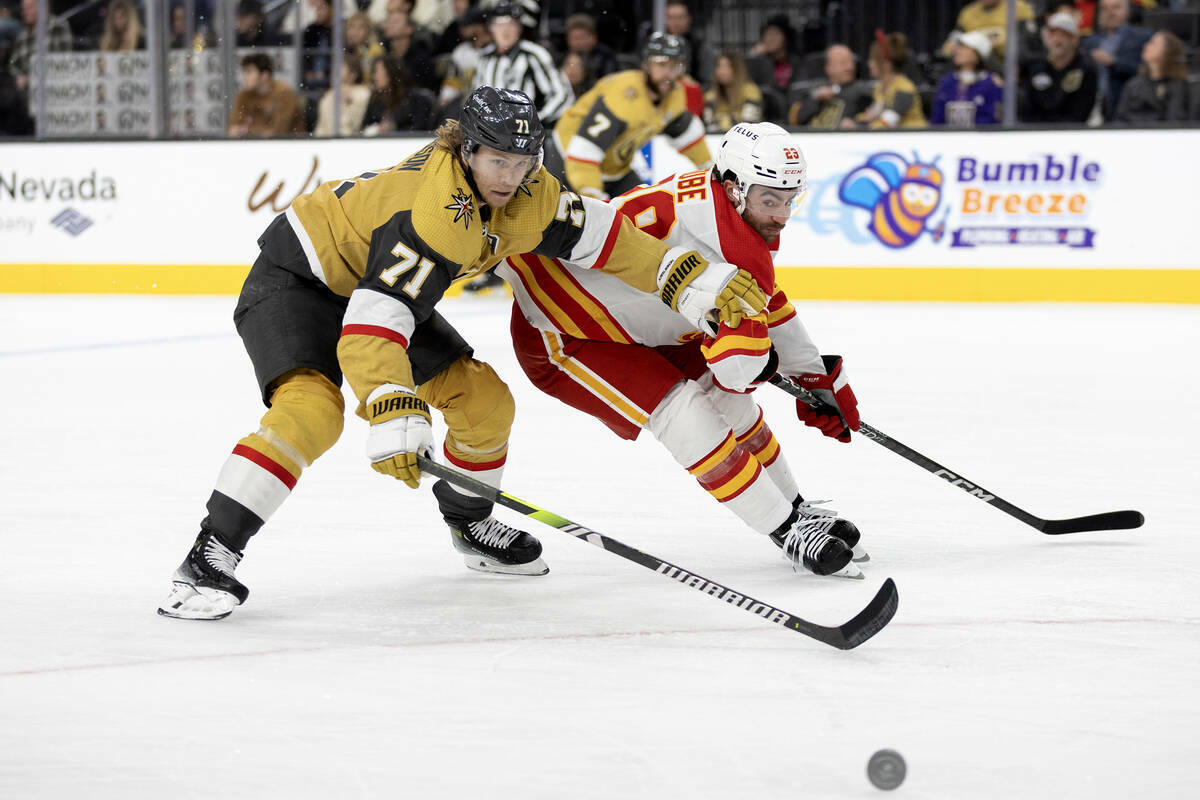 El centro de los Golden Knights William Karlsson (71) y el centro de los Flames Dillon Dube (29 ...