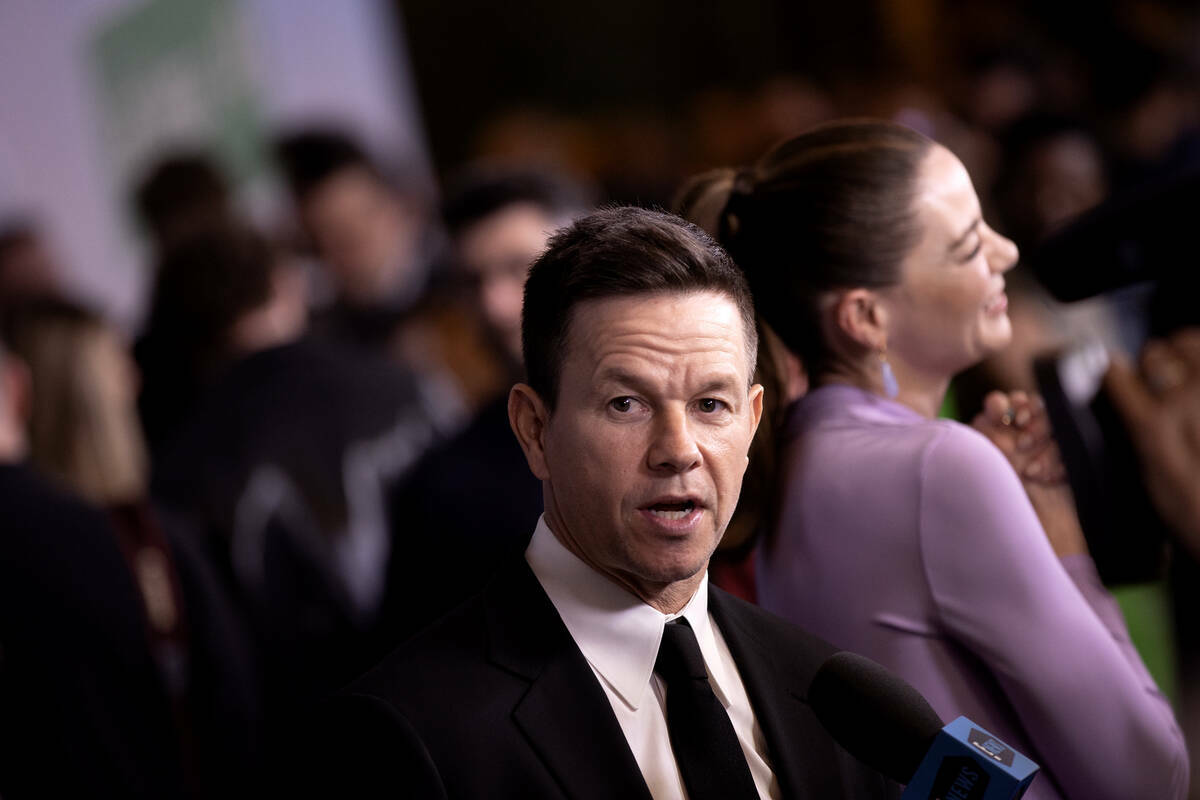 El actor y productor Mark Wahlberg habla con reporteros en la alfombra roja durante el estreno ...