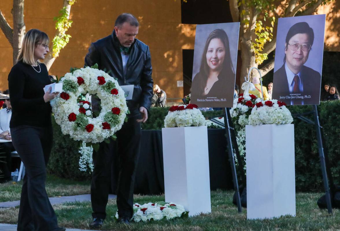 Miembros de la comunidad de la UNLV se preparan para colocar una corona de flores delante de la ...