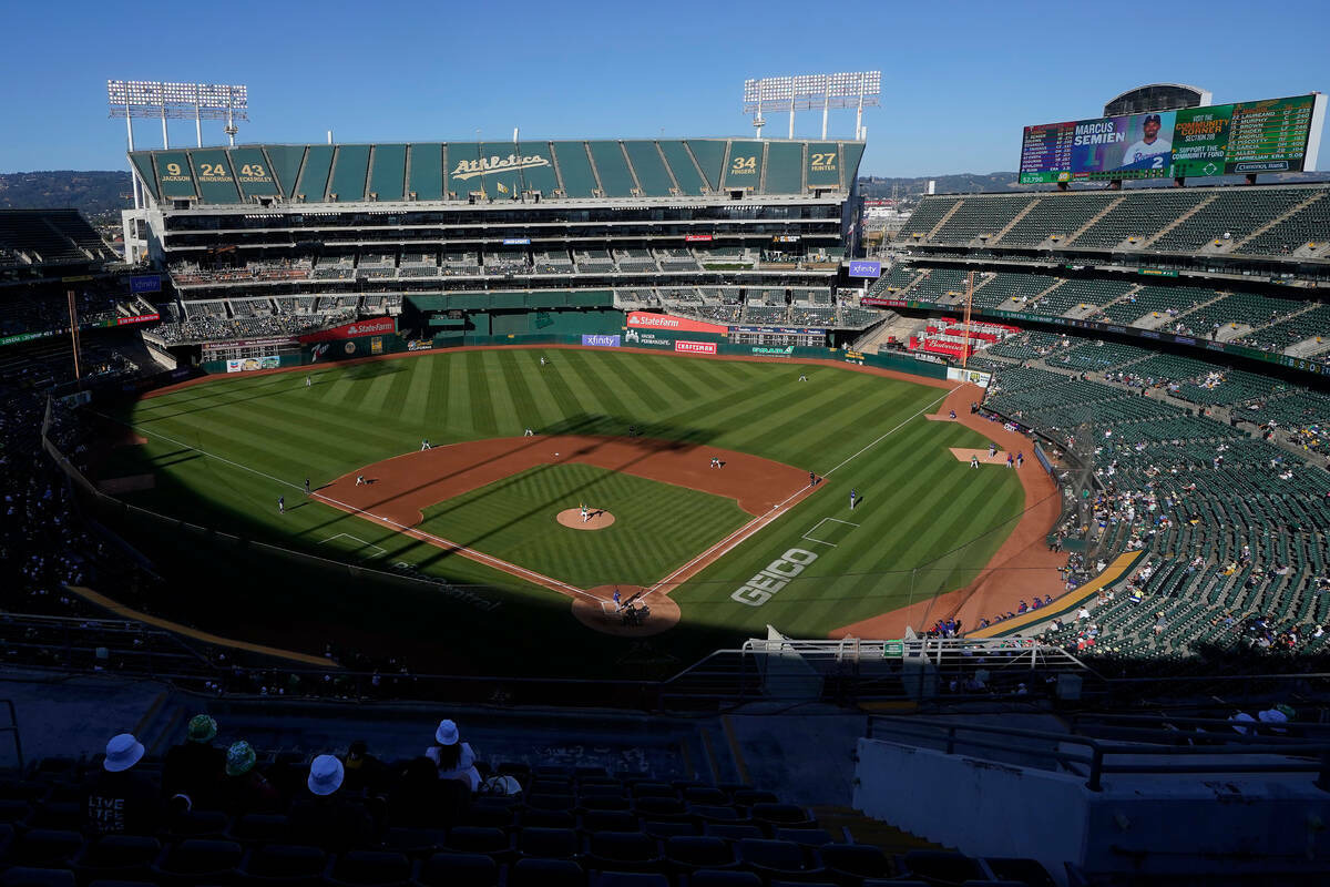 Fanáticos observan un partido de béisbol en el Oakland Coliseum entre los Oakland Athletics y ...