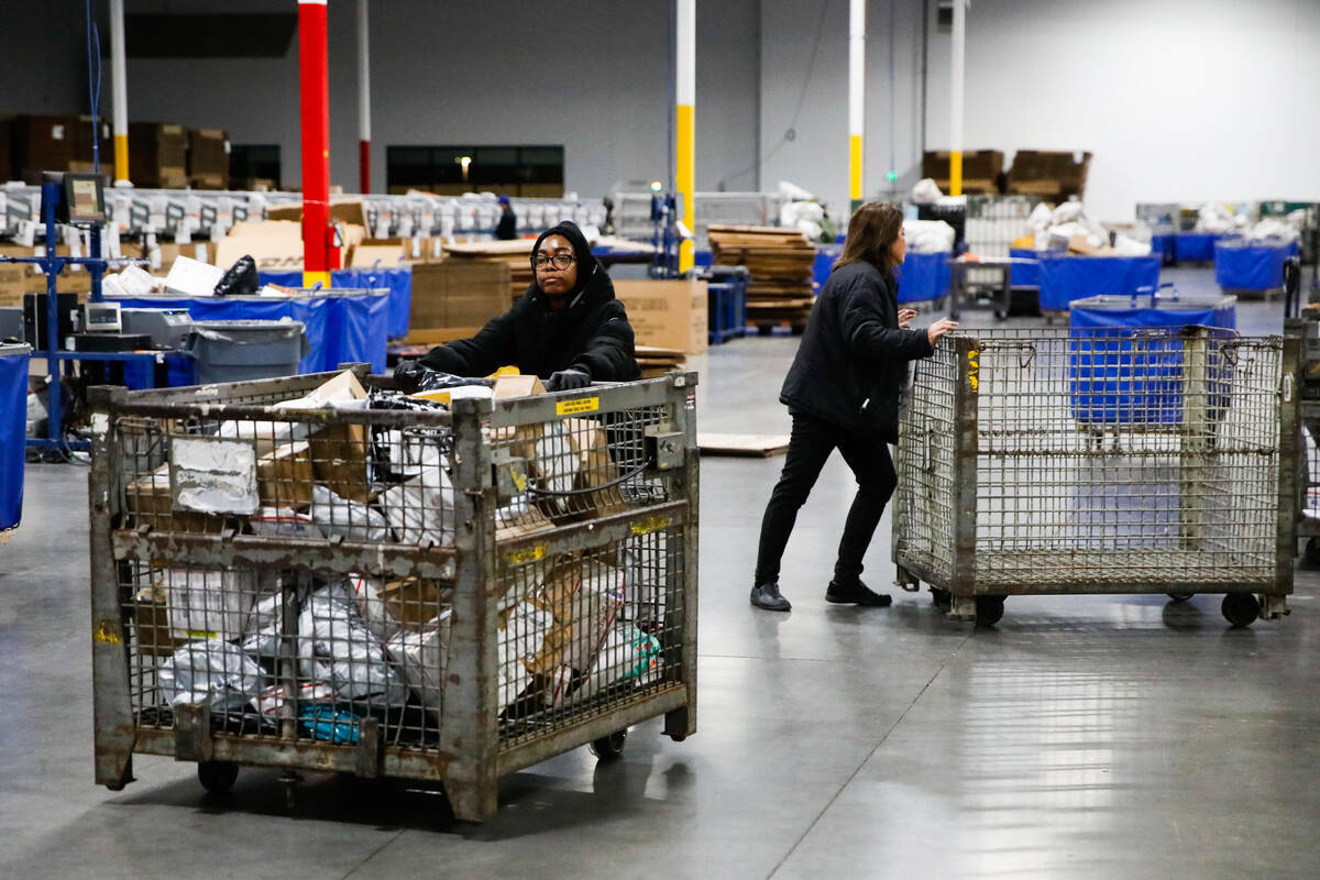 Empleados de USPS clasifican paquetes en un centro de distribución a menos de dos semanas de N ...