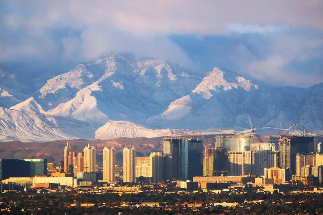 La luz del sol matutino ilumina el Strip de Las Vegas y las Spring Mountains cubiertas de nieve ...
