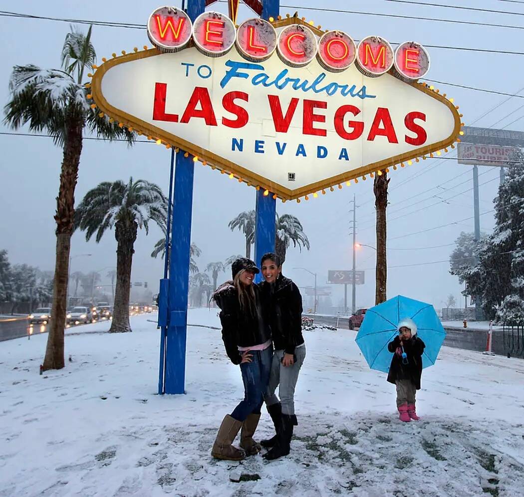 Los visitantes se hacen una foto en la señal de bienvenida durante una tormenta de nieve en el ...