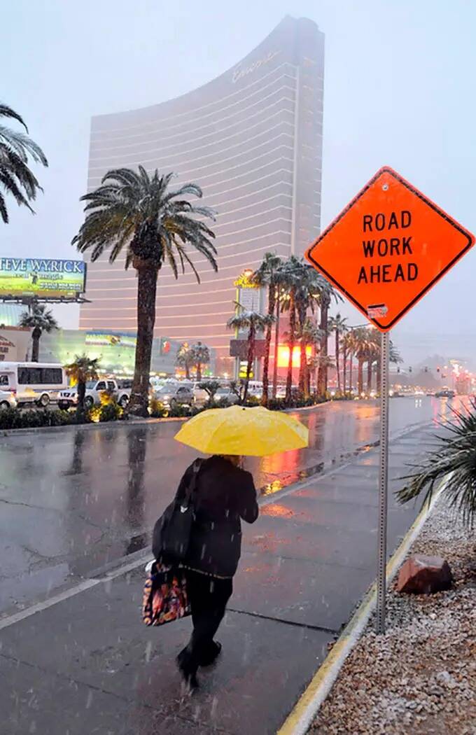 Una mujer hace frente a los elementos mientras camina por el Strip de Las Vegas, cerca del Enco ...