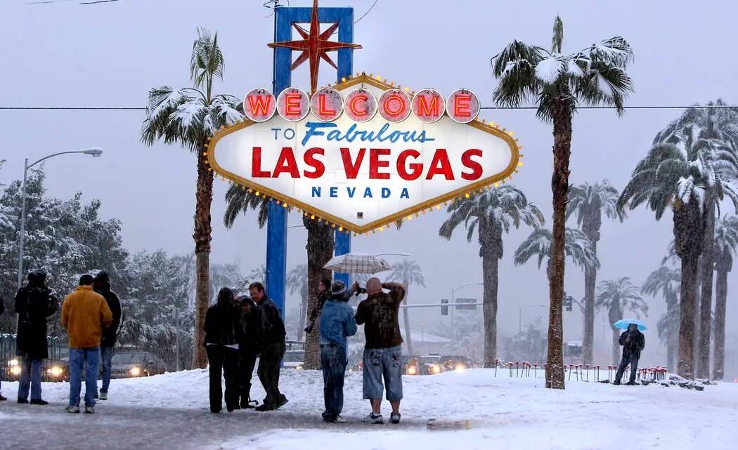 La gente visita la señal de bienvenida en el Strip de Las Vegas para tomar fotos mientras cae ...
