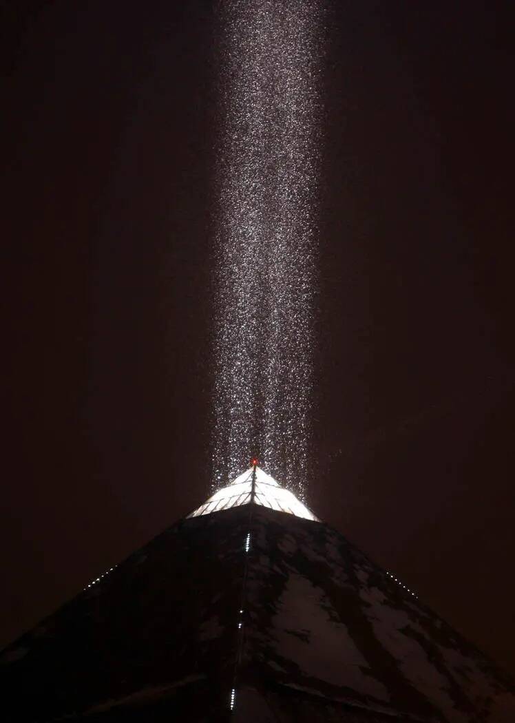La luz en lo alto del Luxor ilumina la nieve que cae en Las Vegas Strip el 17 de diciembre de 2 ...