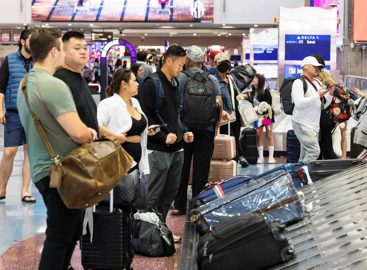 Pasajeros esperan su equipaje en la zona de recolección de equipajes de la Terminal 1 del Aero ...