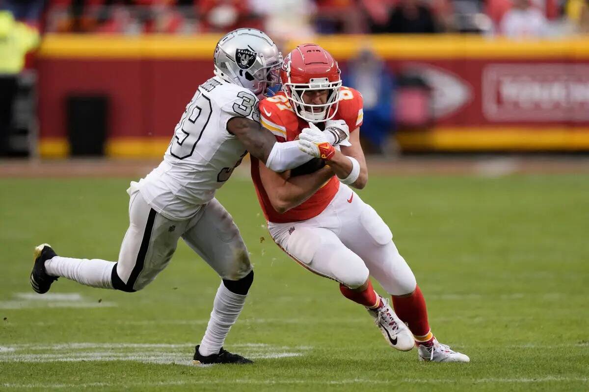 El tight end de los Kansas City Chiefs Travis Kelce, derecha, es detenido por el cornerback de ...