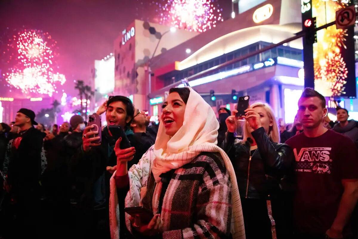 Fiesteros de Año Nuevo observan los fuegos artificiales en el Strip el sábado 31 de diciembre ...