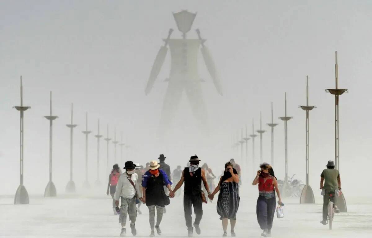 Visitantes de Burning Man caminan entre el polvo en el evento anual Burning Man en el desierto ...