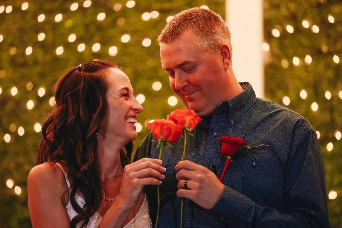 Kendra Smith, a la izquierda, observa a Kent Hagerman mientras sostienen rosas durante su cerem ...