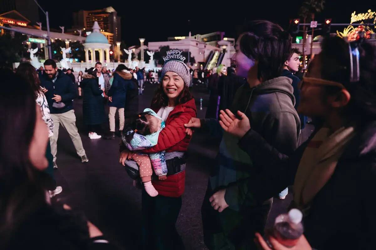 Un niño dormido es sostenido durante las celebraciones de Año Nuevo en el Strip el domingo 31 ...