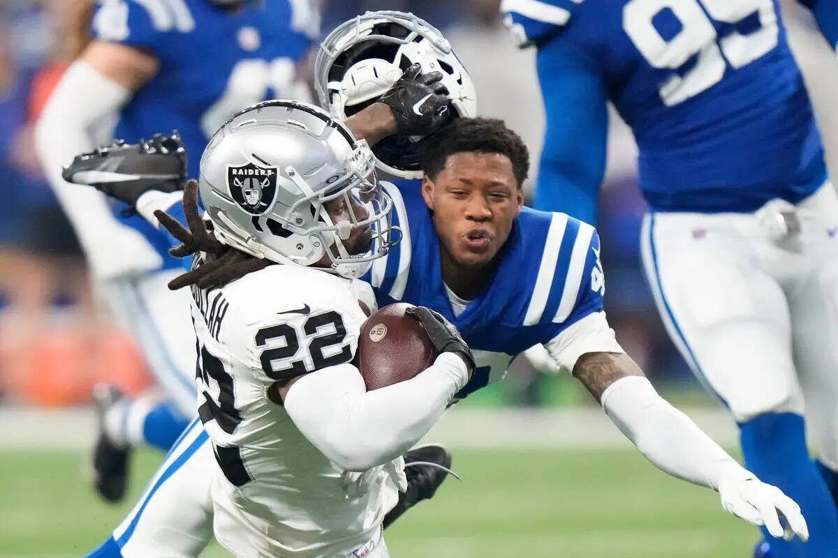 El cornerback de los Indianapolis Colts Jaylon Jones, a la derecha, pierde su casco al taclear ...