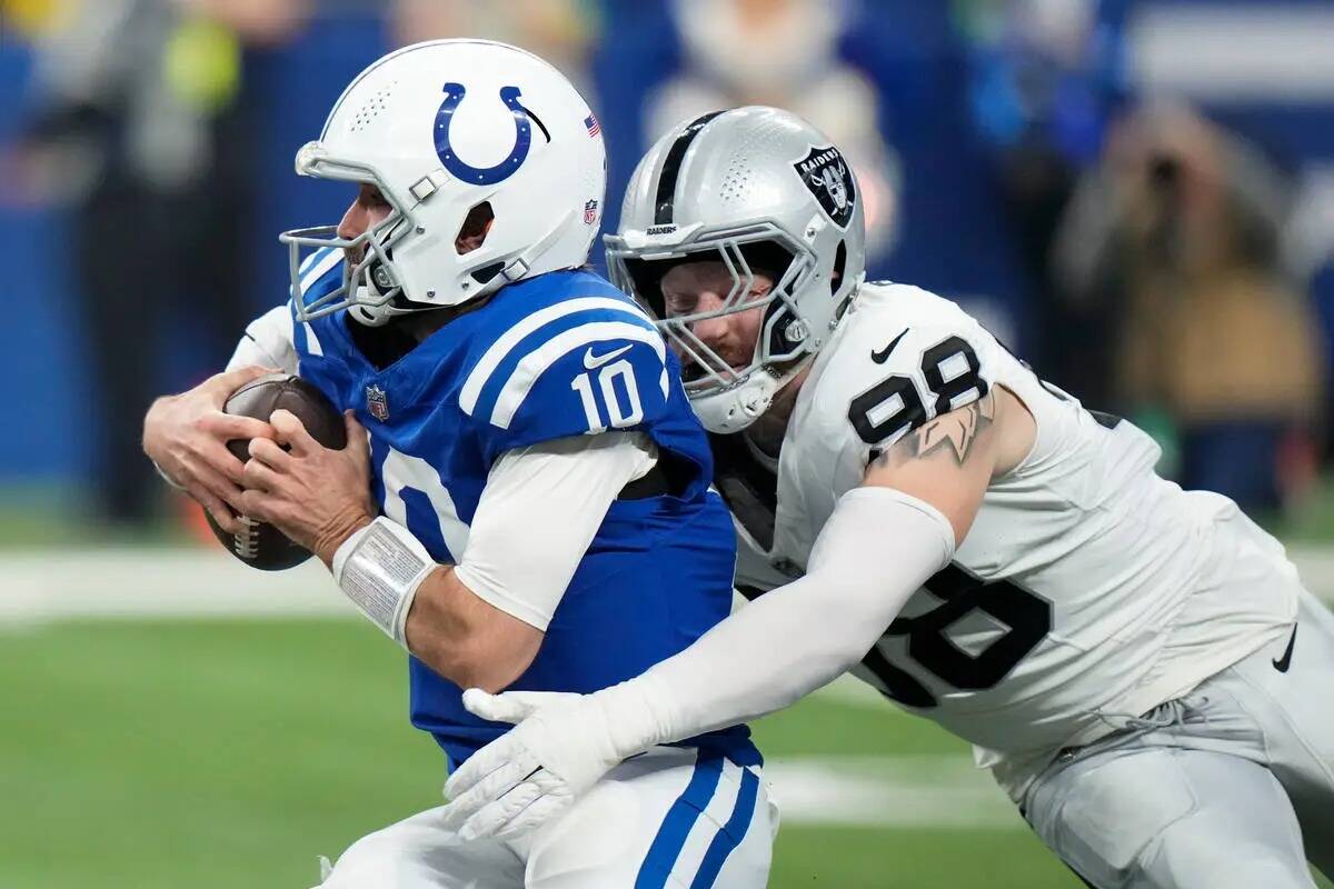 El quarterback de los Indianapolis Colts Gardner Minshew (10) es tacleado por el defensive end ...