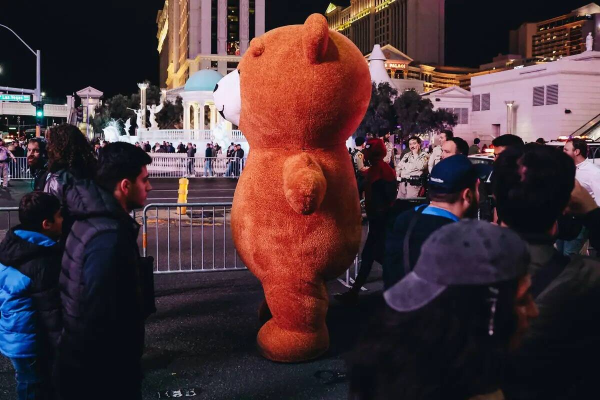 Un oso de peluche gigante pasa junto a los peatones el domingo 31 de diciembre de 2023, en Las ...