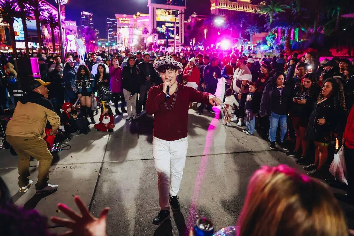 Un músico callejero se presenta ante una multitud de fiesteros de Año Nuevo el domingo 31 de ...
