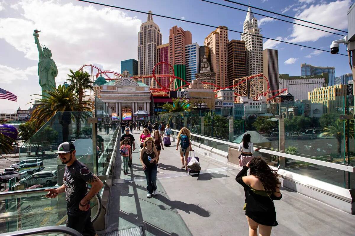 La gente camina por el puente peatonal entre el New York-New York y el MGM Grand el 28 de marzo ...