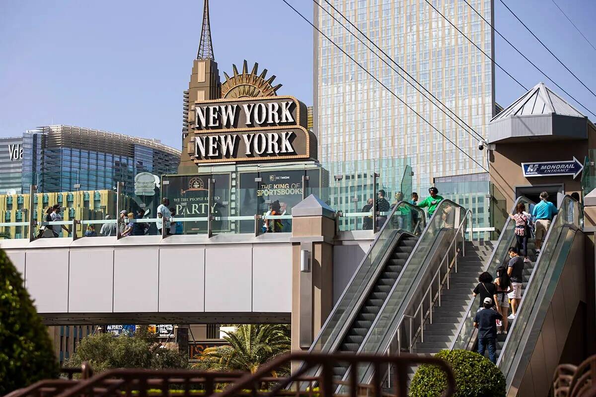 La gente camina a lo largo del puente peatonal entre el New York-New York y el MGM Grand el 28 ...