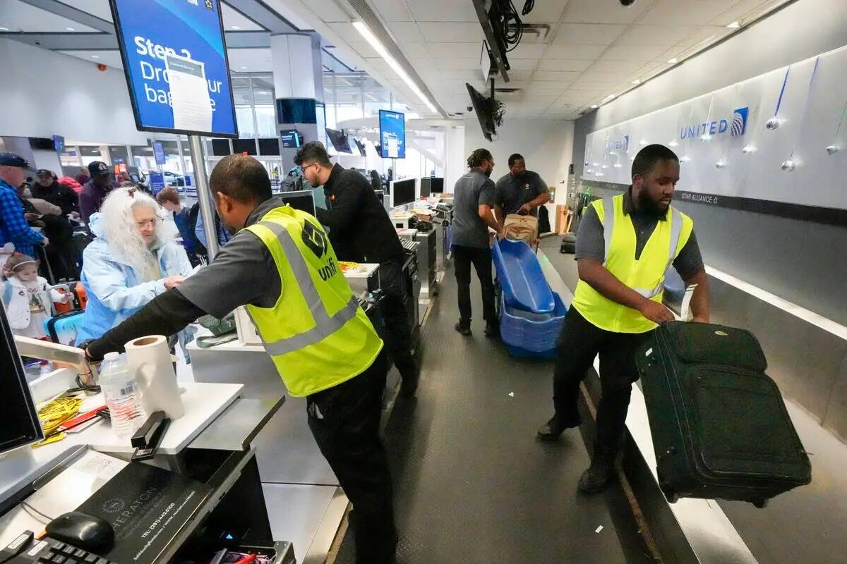 Archivo - Agentes facturan a pasajeros y su equipaje en el Aeropuerto Intercontinental George B ...