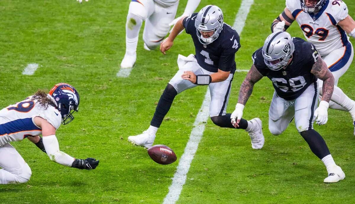 El quarterback de los Raiders Aidan O'Connell (4) observa un balón suelto mientras el lineback ...
