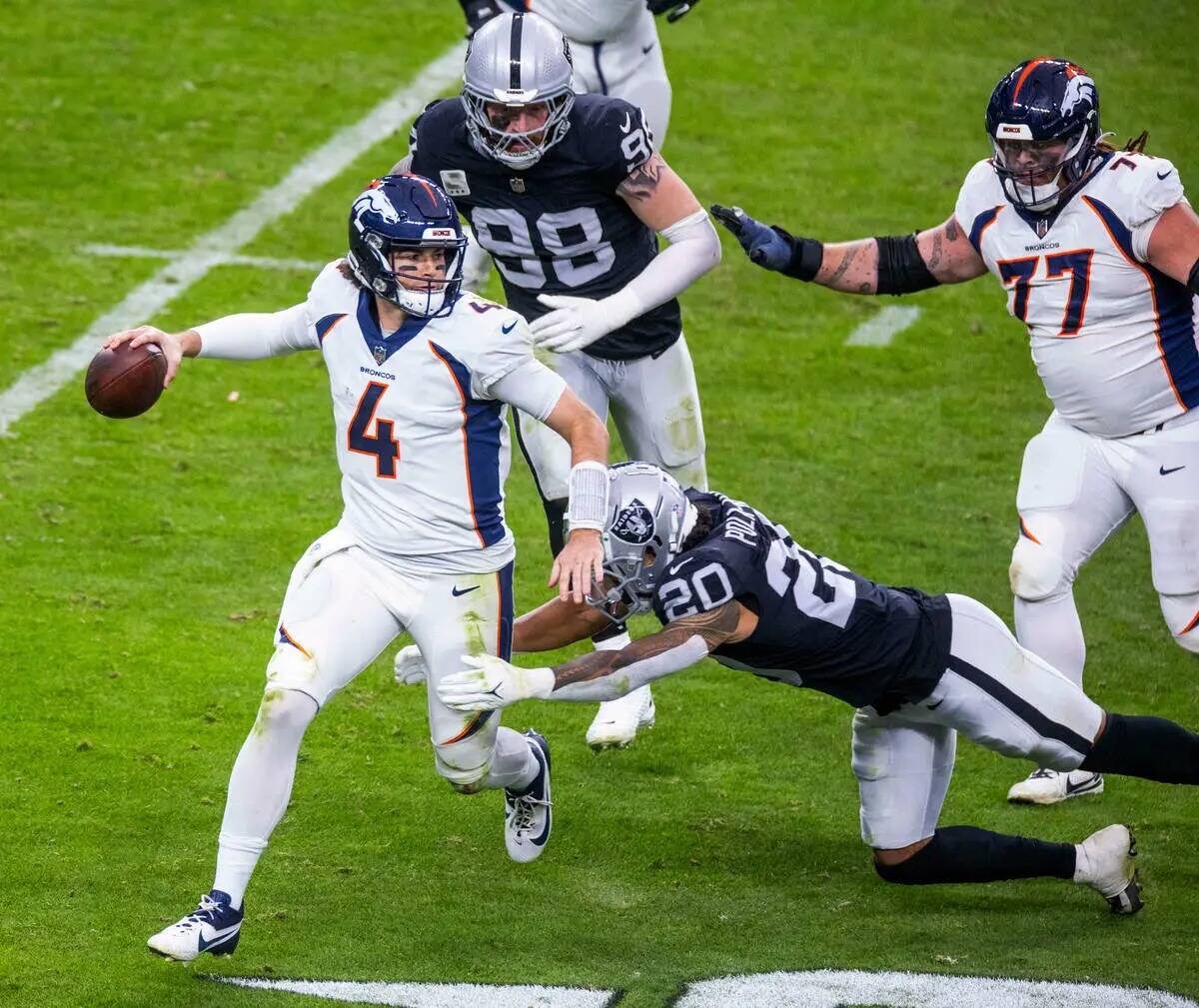 El quarterback de los Denver Broncos Jarrett Stidham (4) es derribado por el safety de los Raid ...