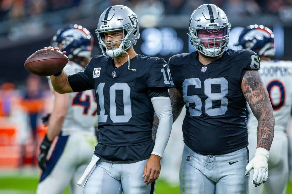 El quarterback de los Raiders Jimmy Garoppolo (10) camina fuera del campo con el centro Andre J ...