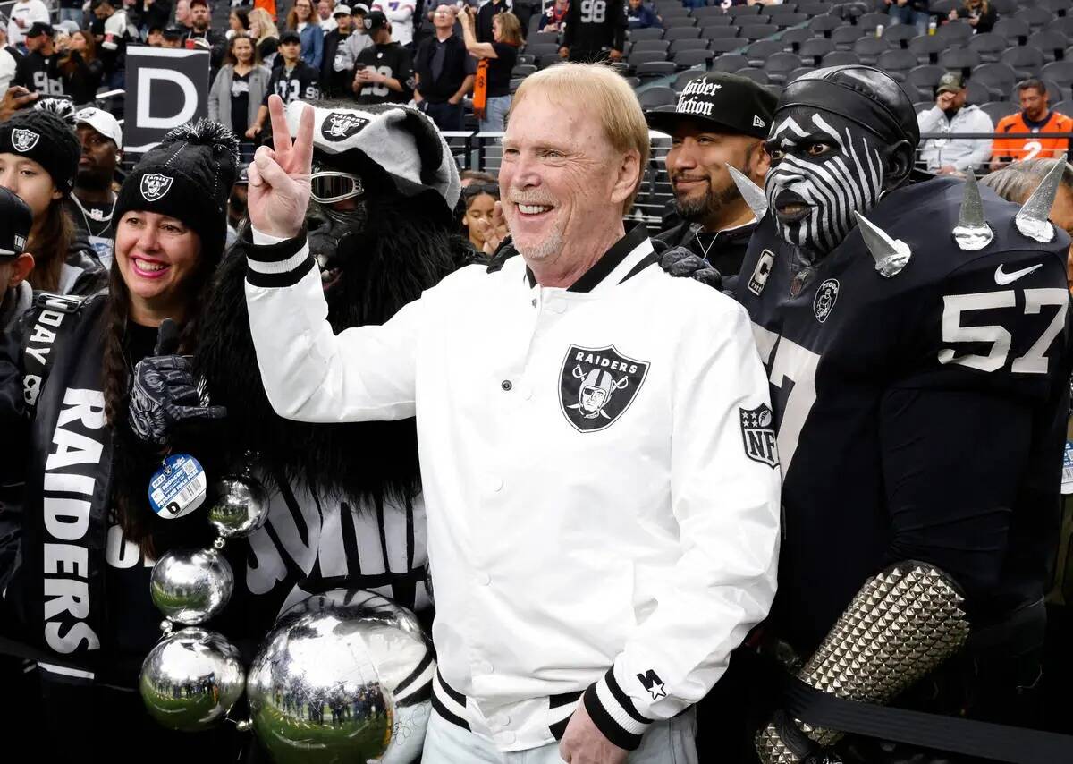 El dueño de los Raiders, Mark Davis, muestra un signo de victoria mientras posa para una foto ...